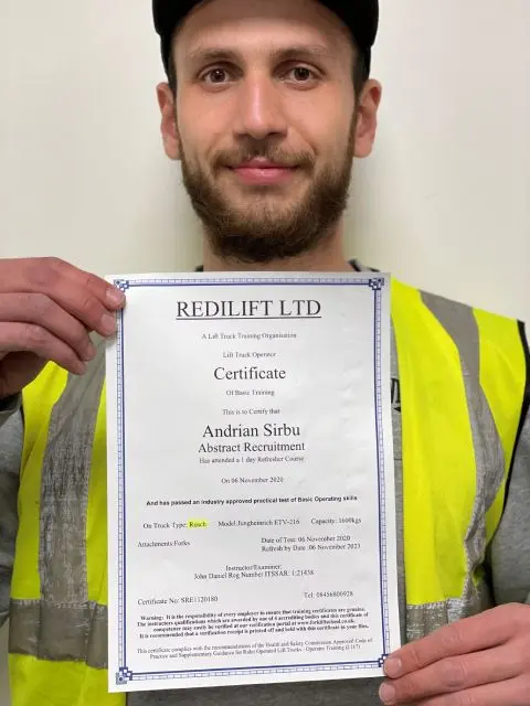Agency colleague holding his lift truck operator training certificate